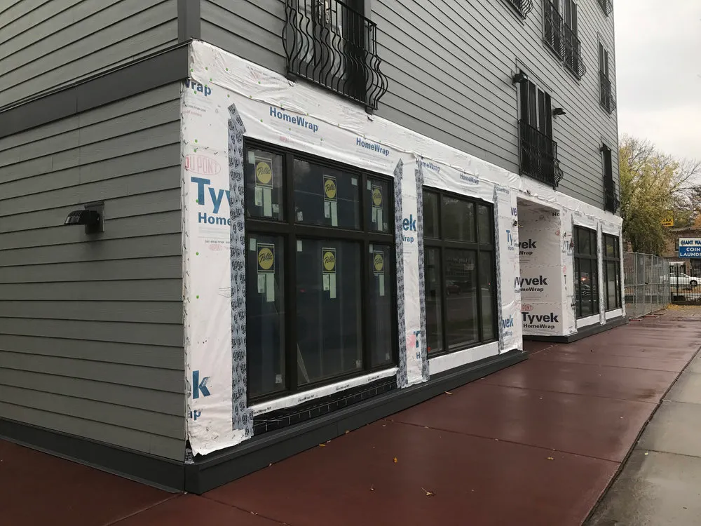 fresh plastic siding liner on the ground level of a building with new windows